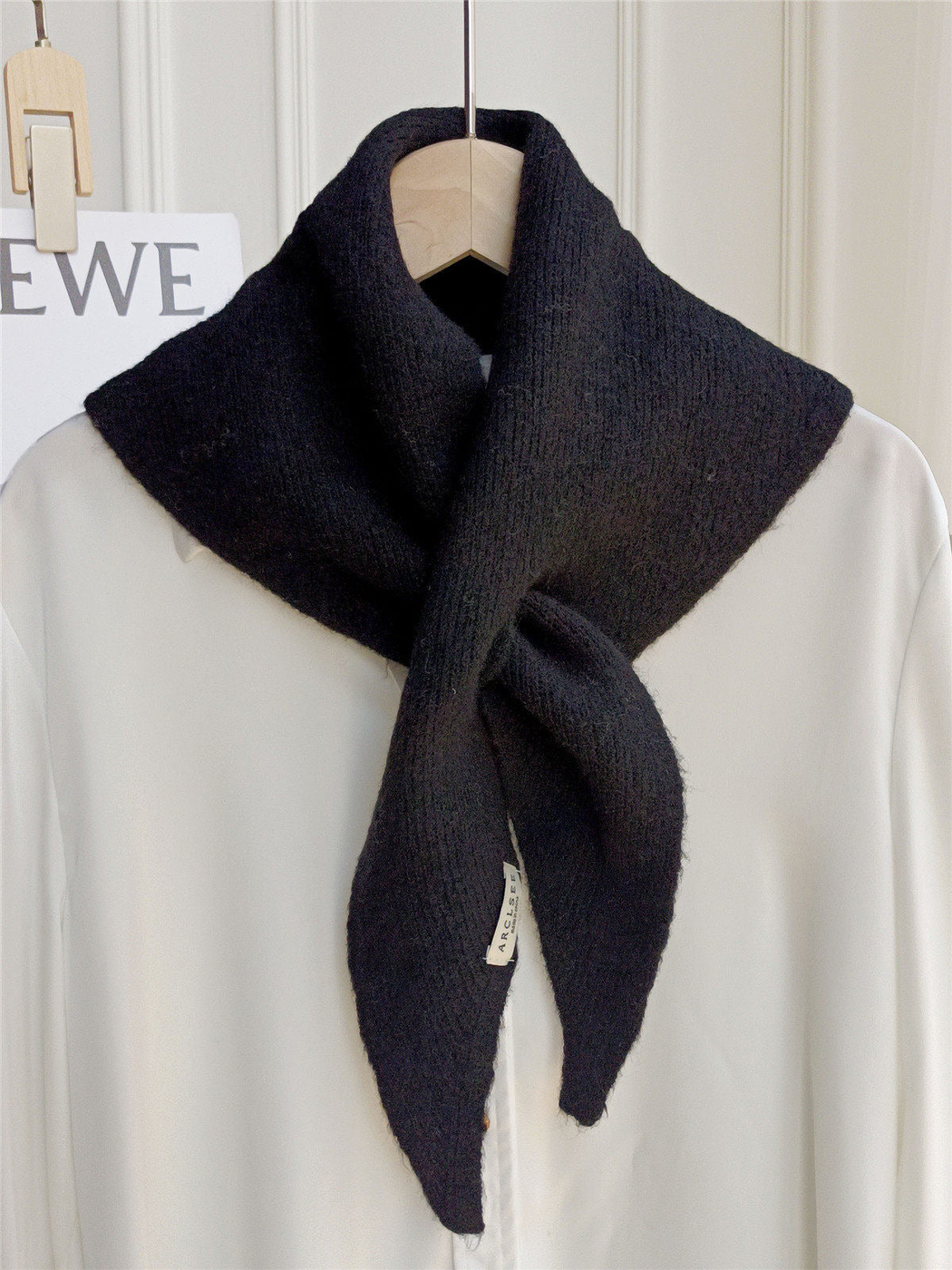 Black pull-through scarf displayed on a white shirt