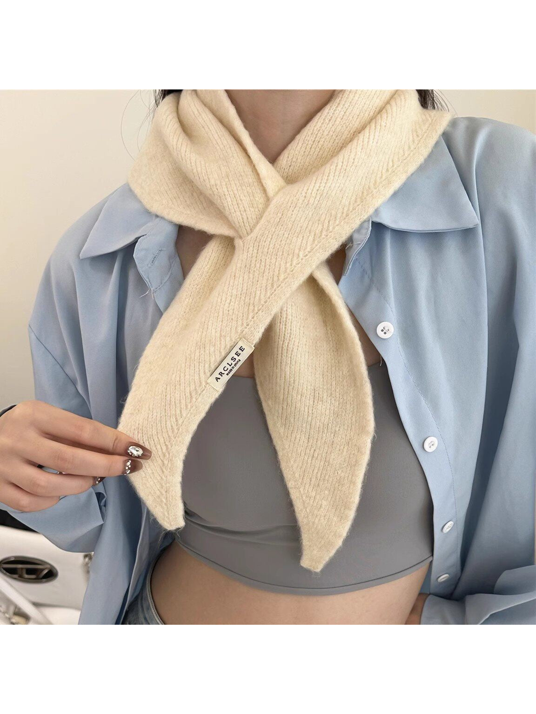 Cream pull-through scarf worn with a light blue shirt