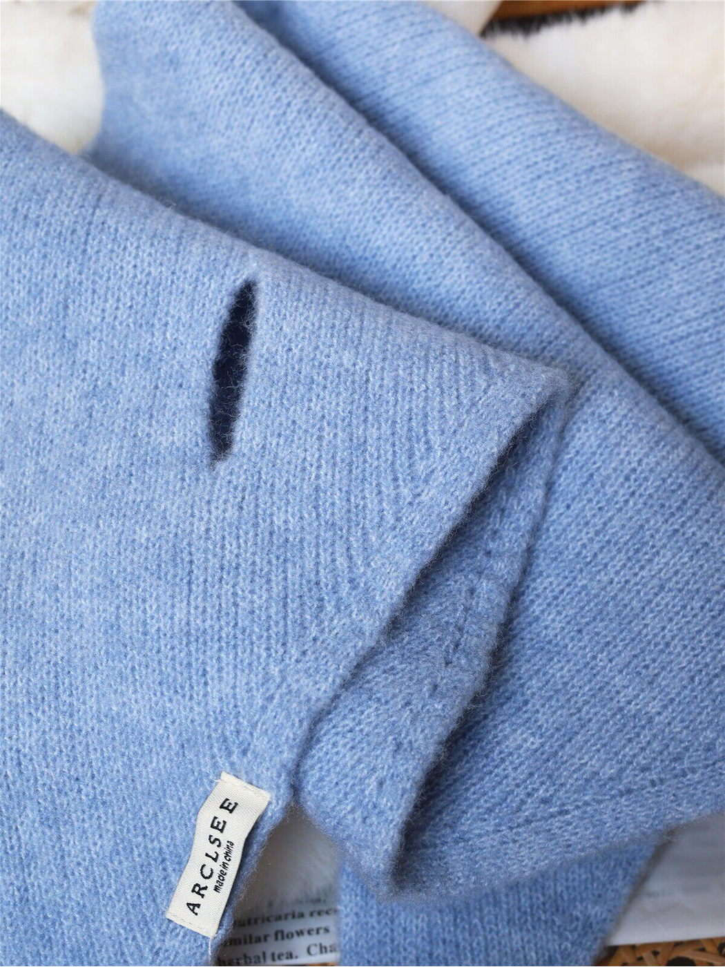 Close-up of the pull-through slit and fine fuzzy knit texture