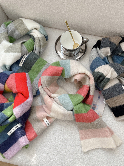 Four striped scarf colorways arranged together in a styled overhead display