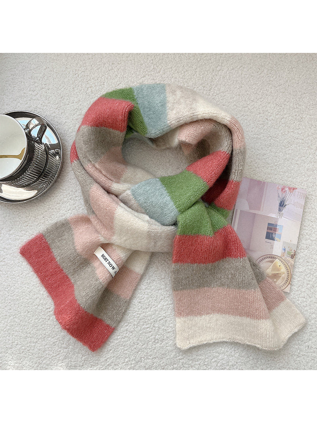 Ivory, pink, coral, green and light blue striped scarf arranged in a loose knot