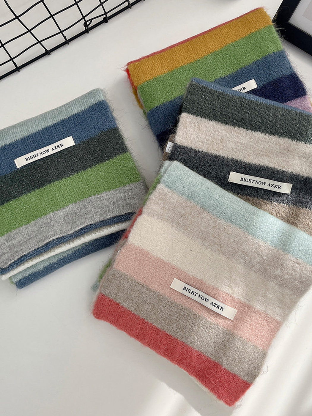 Four folded striped scarf colorways displayed together