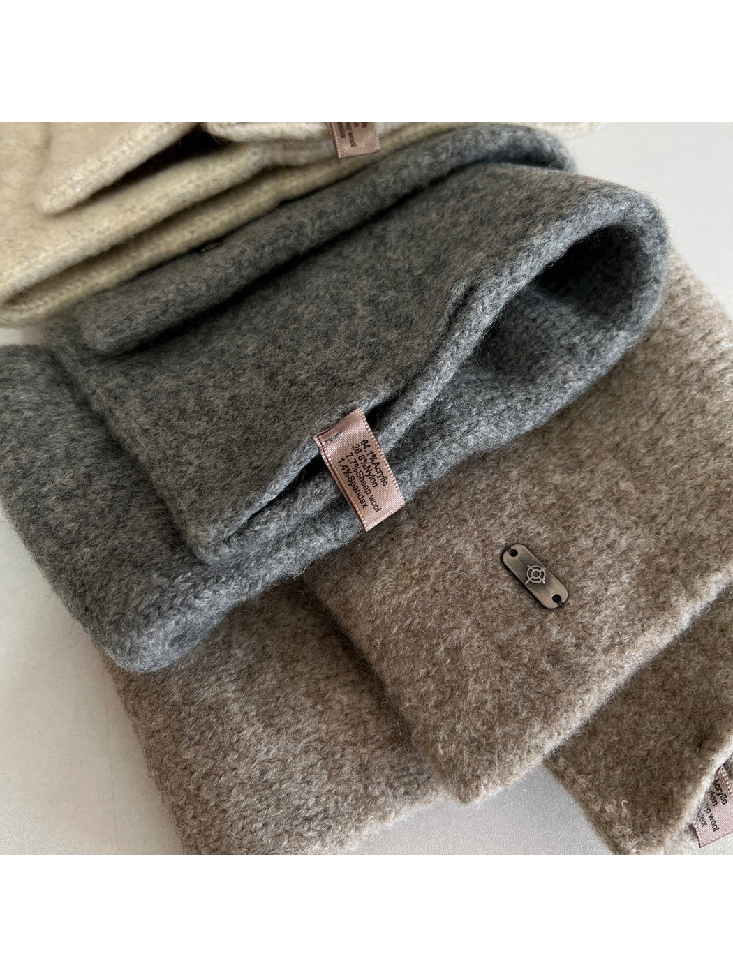 Close-up of the fuzzy knit texture, finished edges, sewn label and metal-tone end plaque