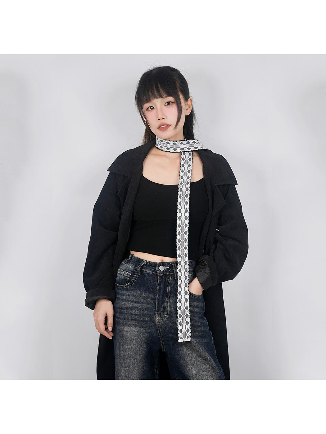 Black lace-trim skinny scarf wrapped once around the neck with one end hanging down