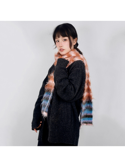 Pink, orange and blue striped fuzzy scarf worn over a dark sweater