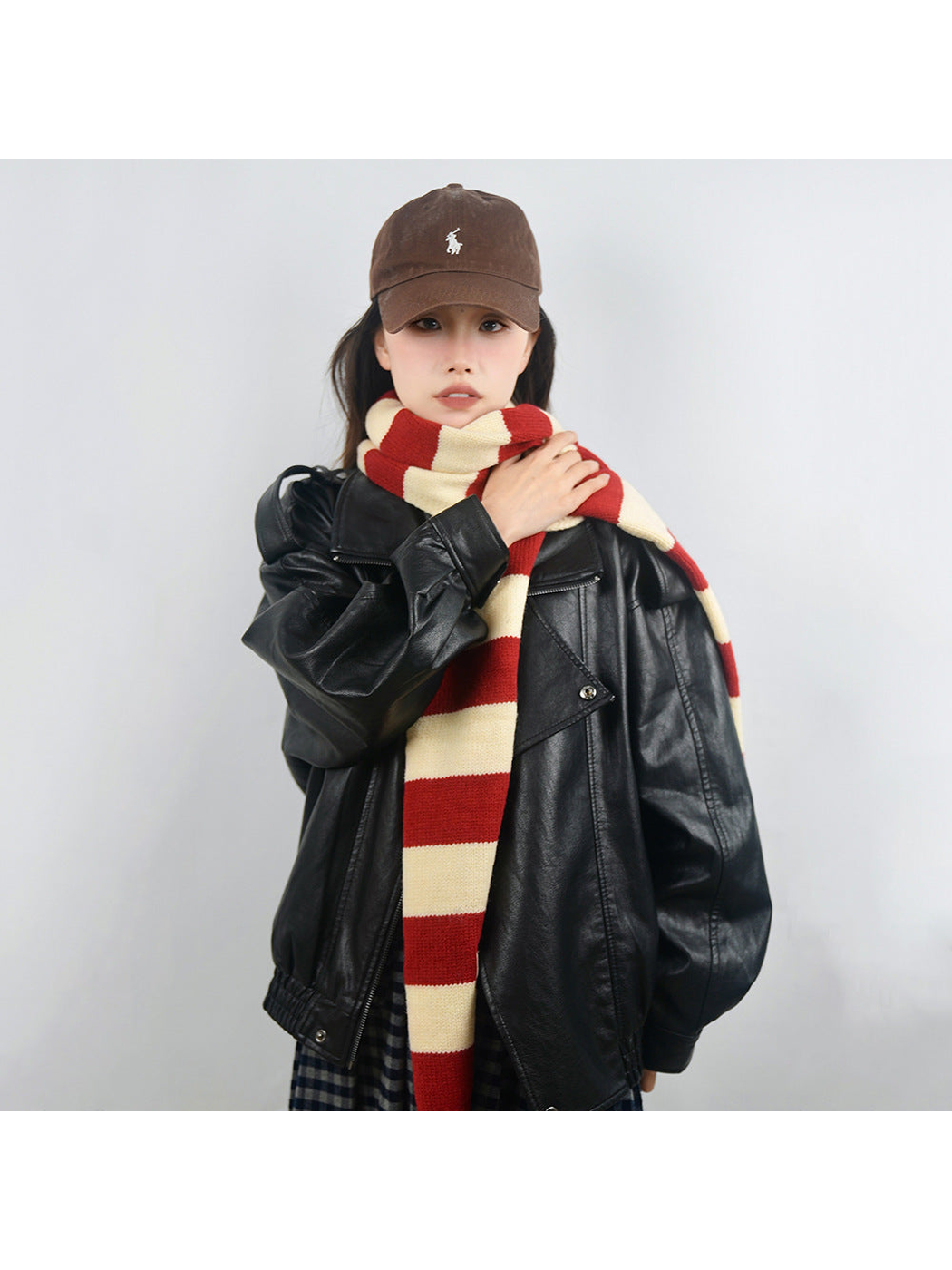 Long red and cream striped scarf worn with one end hanging toward the waist
