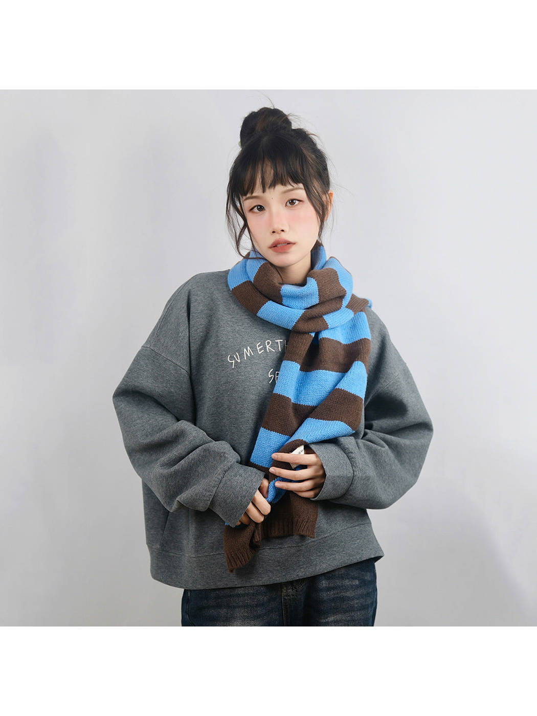Blue and dark brown striped scarf styled with a gray sweatshirt