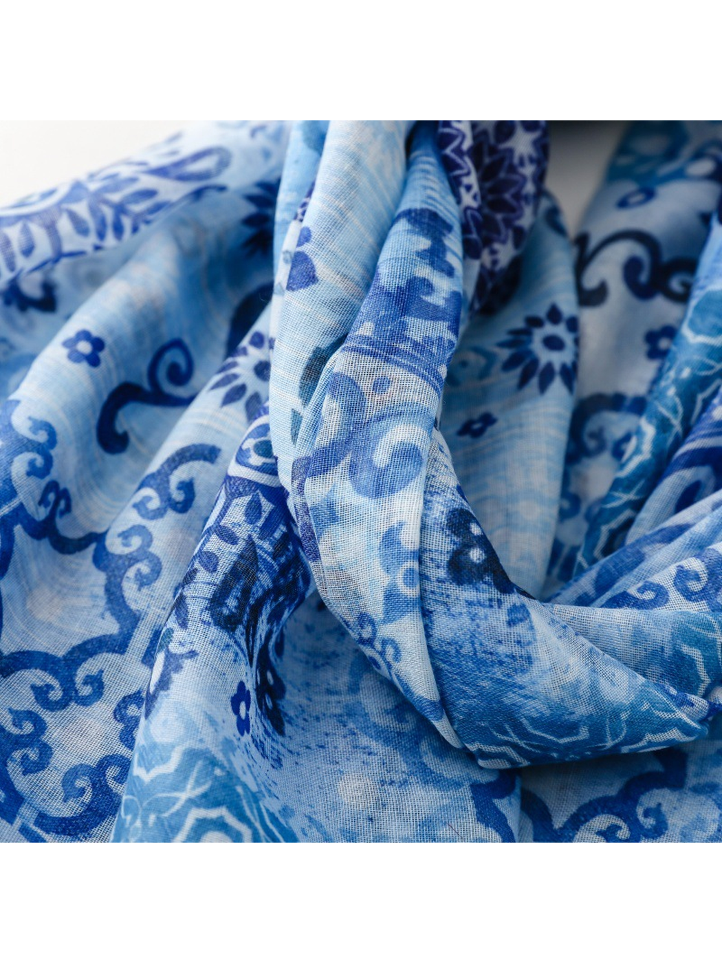 Close-up of the blue printed scarf gathered into soft flowing folds