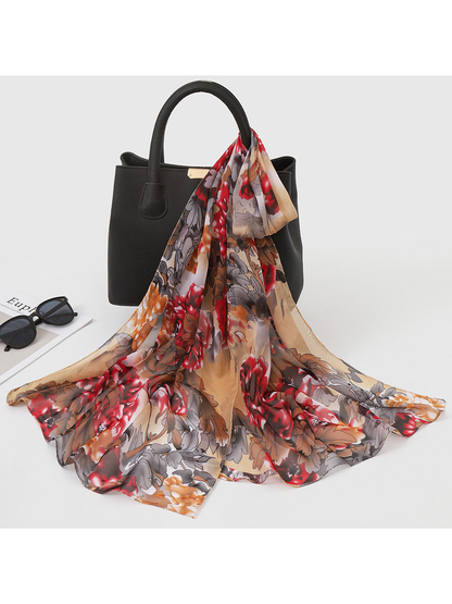 Coffee brown and red floral scarf draped over a black handbag