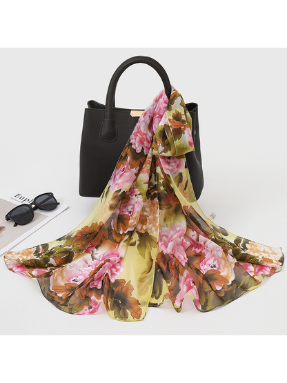 Green, pink and brown floral scarf draped over a black handbag