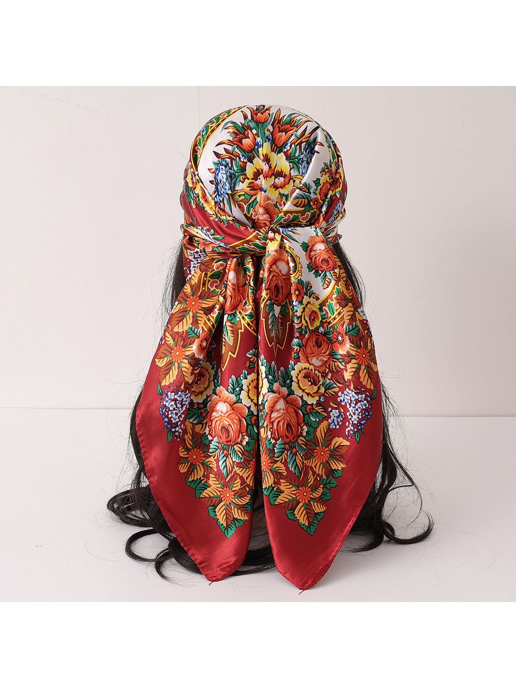 Burgundy floral square scarf tied over a wig display