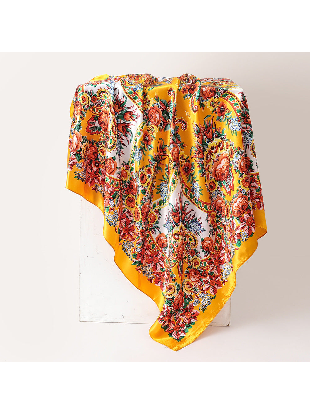 Yellow square scarf with dense floral and paisley print, draped view