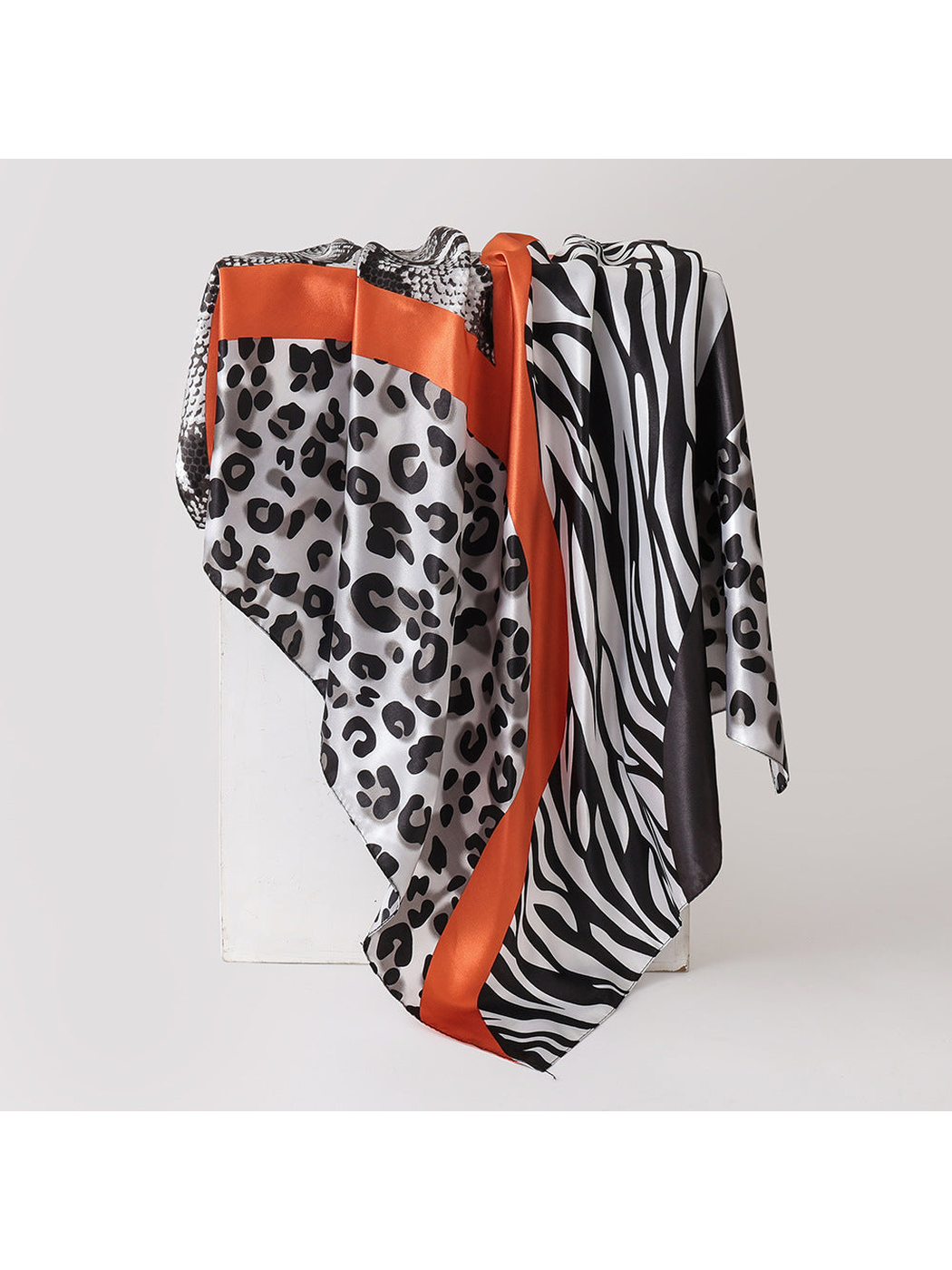 Gray animal-print square scarf with orange trim, draped view