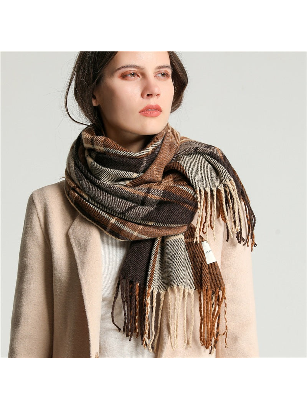 Brown, cream and gray plaid scarf wrapped around the neck with fringed ends layered in front