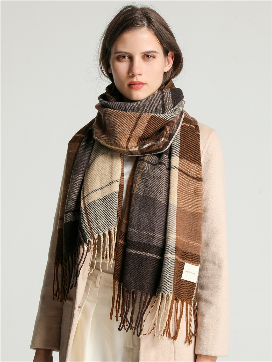 Brown, cream and gray plaid scarf worn with both fringed ends hanging down the front