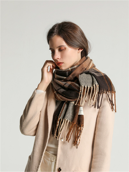 Side view of brown, cream and gray plaid scarf wrapped around the neck with layered fringe