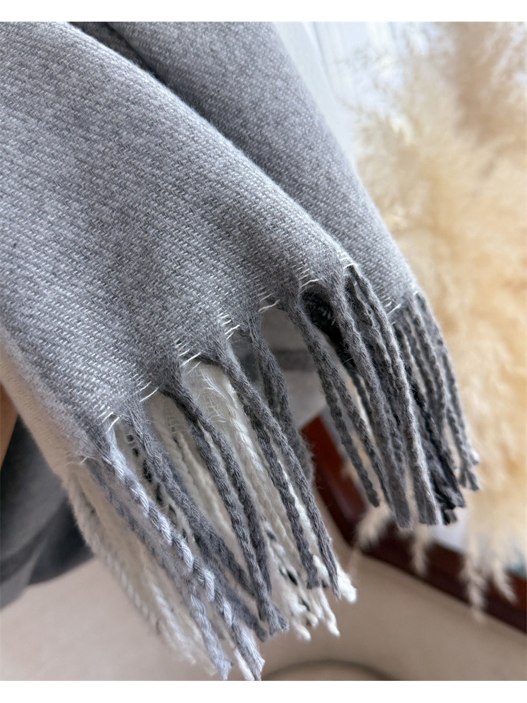 Close-up of gray scarf weave and twisted fringe along the short edge