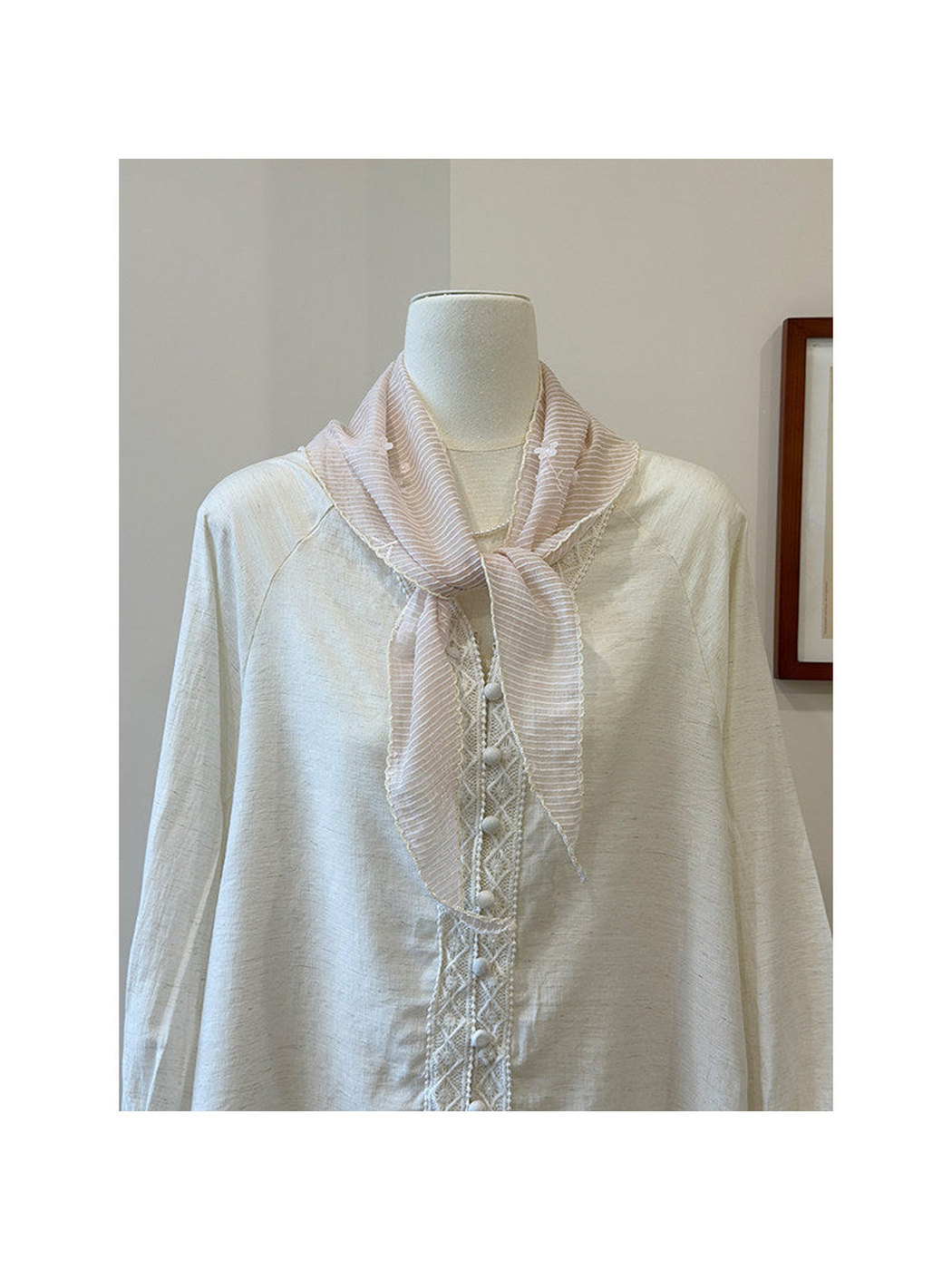 Light pink striped triangle scarf tied around a mannequin neck