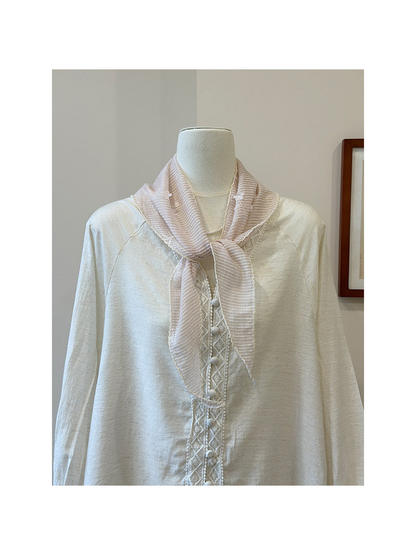 Light pink striped triangle scarf tied around a mannequin neck