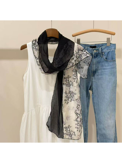 Black sheer scarf with contrasting botanical-print panels, draped view