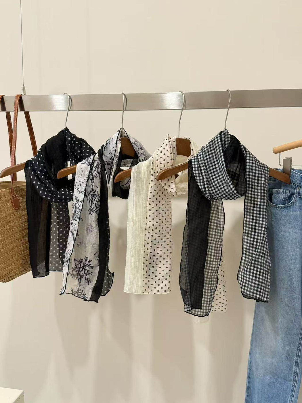 Four contrasting sheer scarf designs displayed on hangers