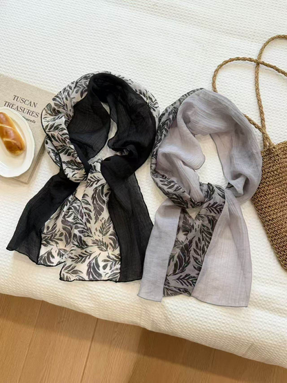 Black and mist gray leaf-print scarves displayed together