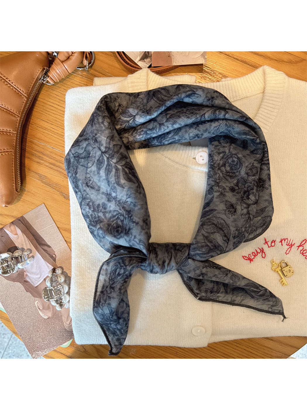 Gray-blue floral scarf tied in a compact neckerchief shape