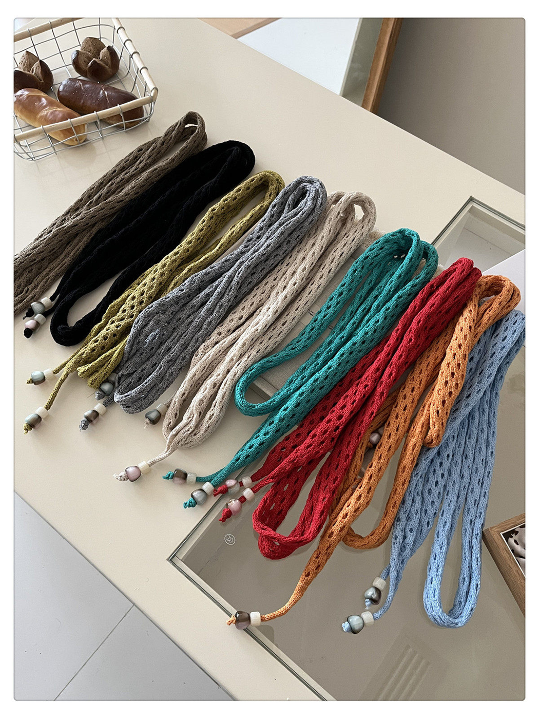 Nine openwork scarf colors arranged together with beaded tapered ends