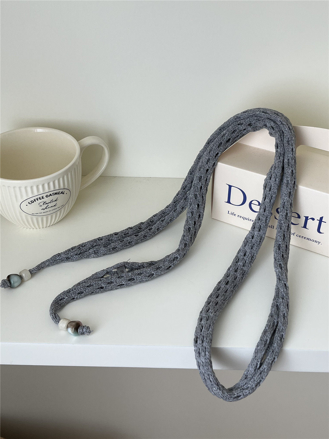 Gray openwork scarf with tapered ends and bead accents