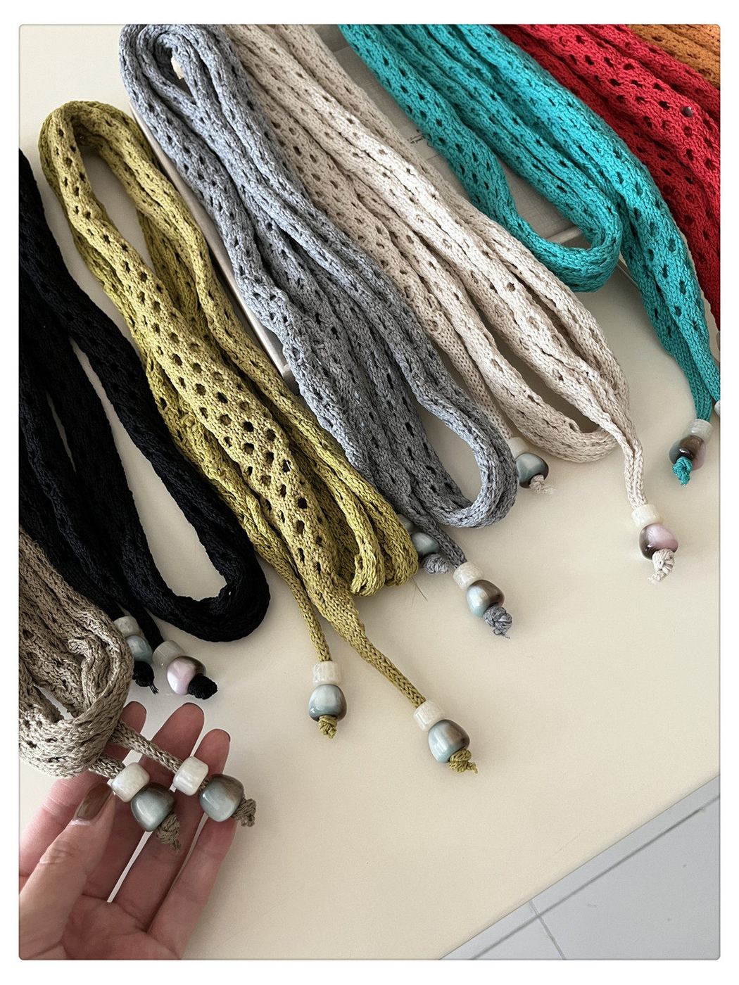 Close-up of openwork texture, tapered scarf ends and contrasting bead accents