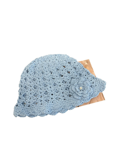 Light blue openwork beanie with scalloped brim and flower applique, angled view