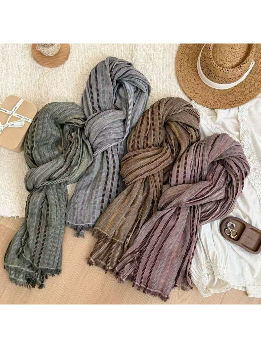Green, gray, brown and pink striped scarves displayed with fringed ends