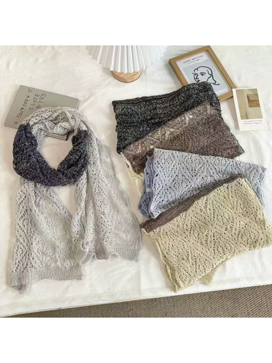 Two-tone openwork scarves arranged flat and folded to show their patterns