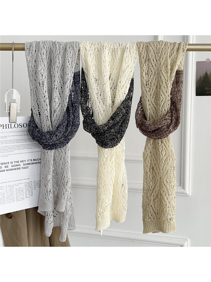 Three two-tone openwork scarves hanging at full length on a rail