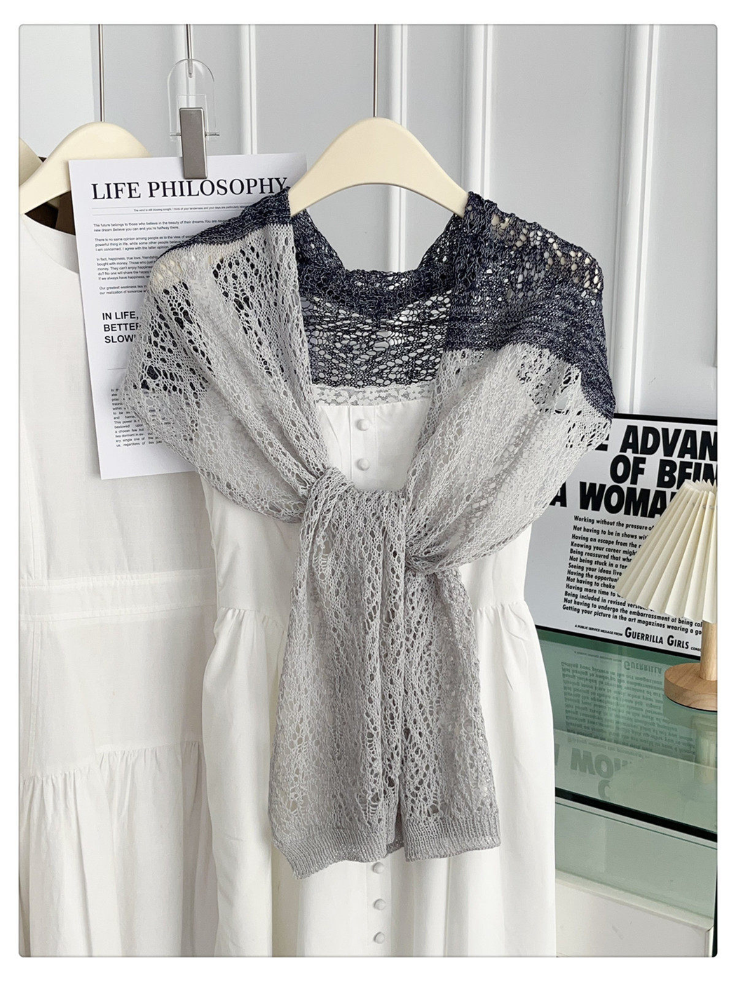 Gray and black openwork scarf tied over a white dress