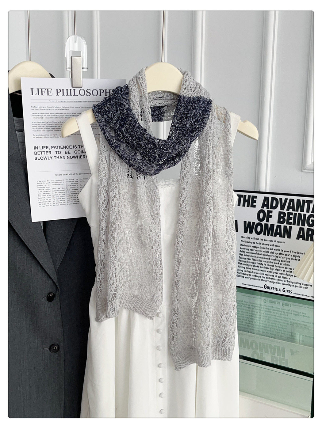 Light gray and black openwork scarf draped in a long front view