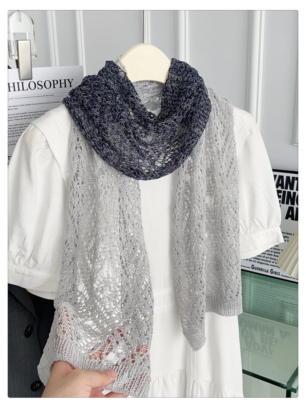 Close view of a gray and black openwork scarf with ribbed end border