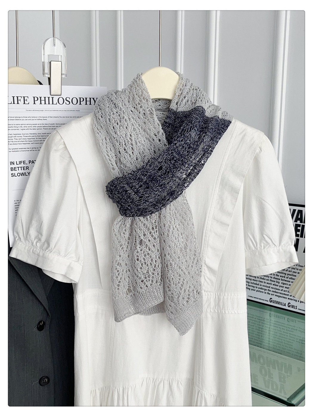 Gray and black openwork scarf styled in a compact crossover knot