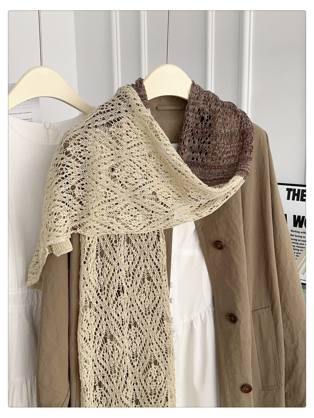 Beige and brown openwork scarf arranged in a wide shoulder drape