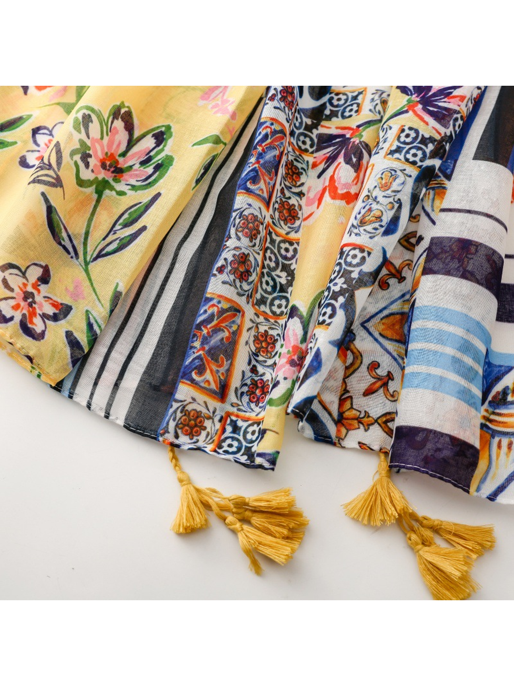 Close-up of the patterned scarf edges with stitched hems and mustard tassels