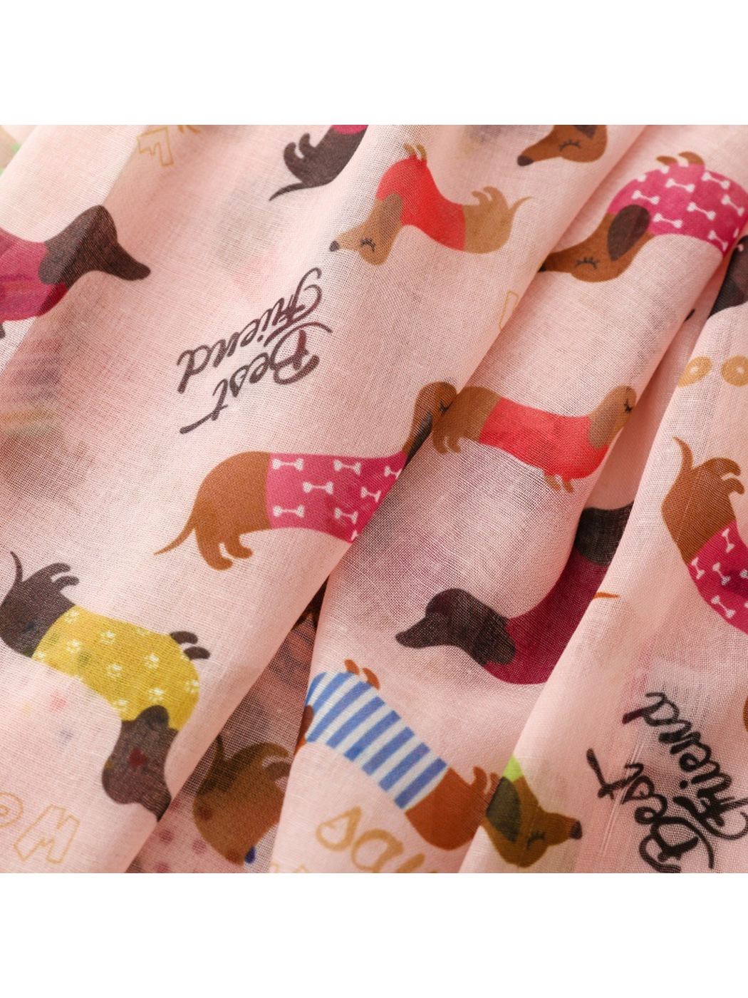 Close-up of colorful dachshund motifs across the light pink scarf
