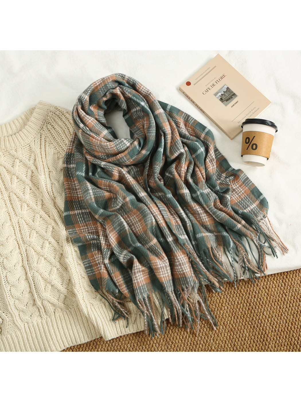 Green and tan plaid scarf arranged with a cream cable-knit sweater