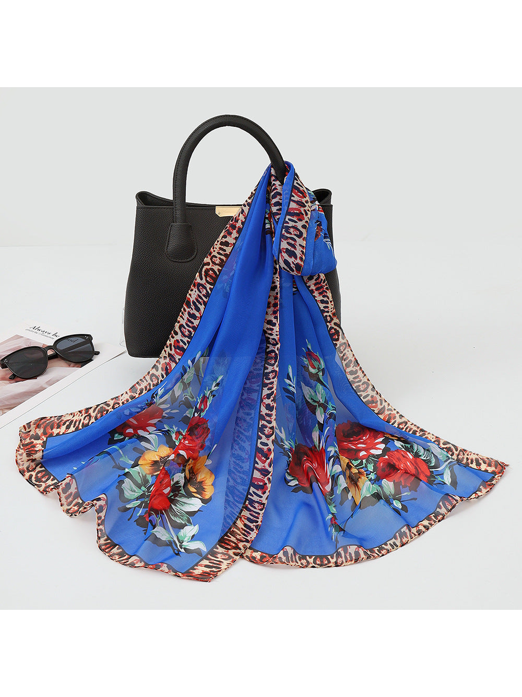 Royal blue sheer floral scarf with leopard-print border, draped view