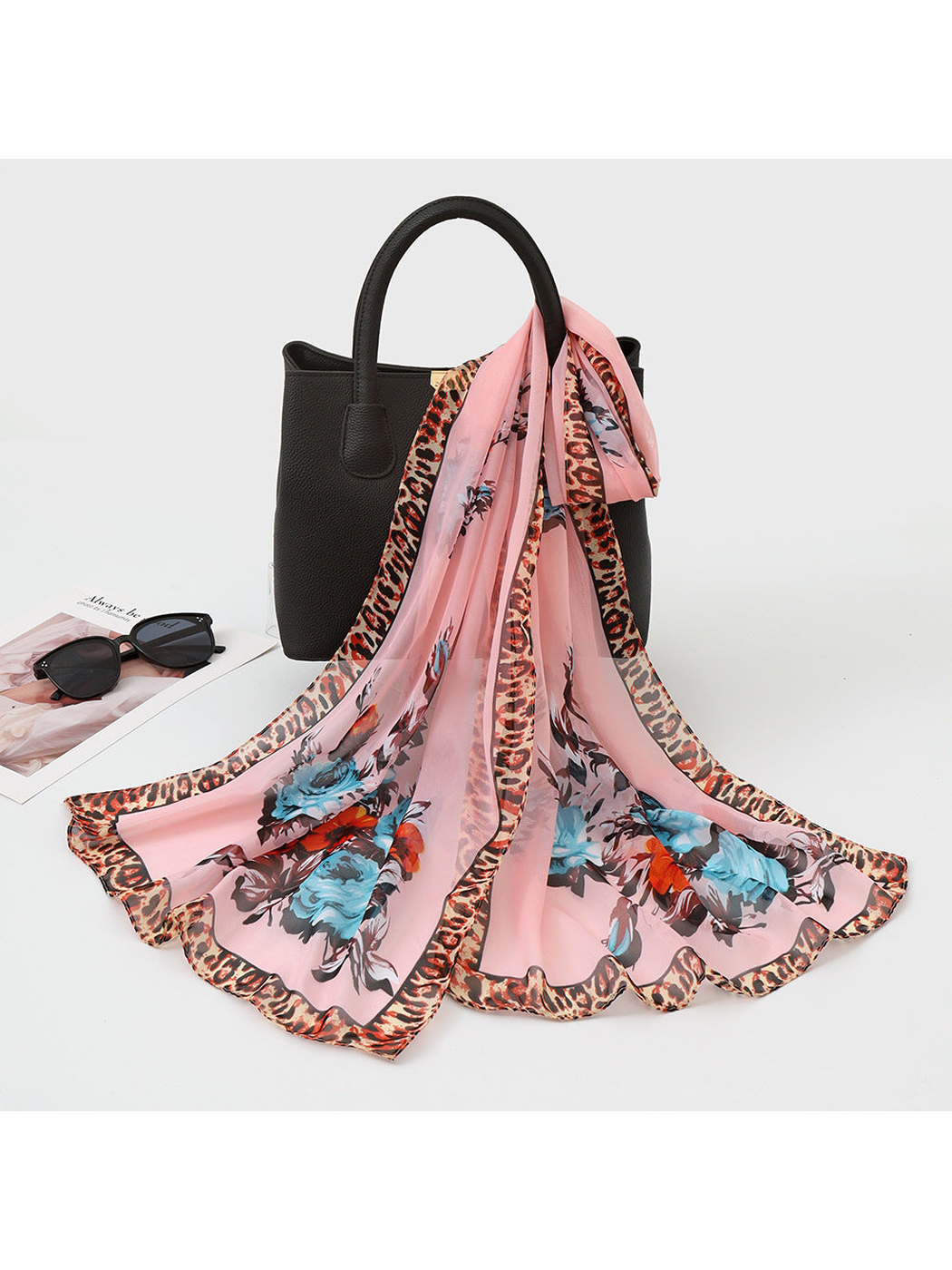Light pink sheer floral scarf with leopard-print border, draped view
