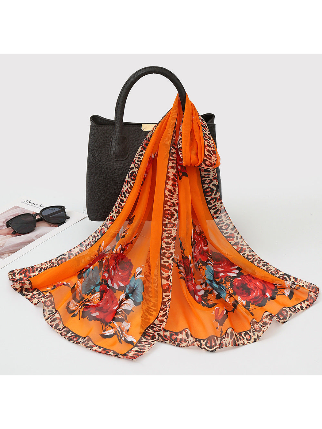 Orange sheer floral scarf with leopard-print border, draped view