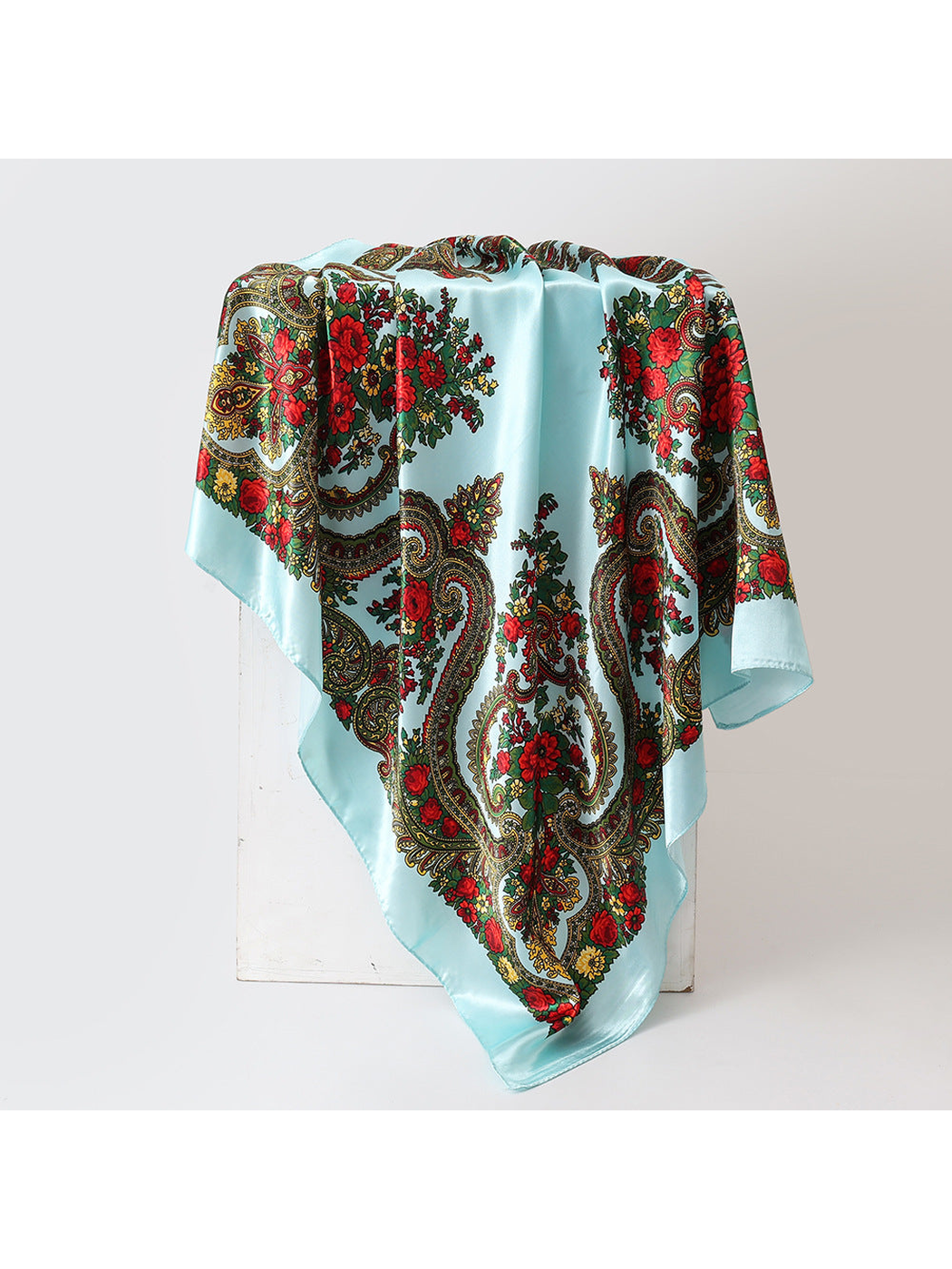 Light blue square scarf with red floral and paisley pattern, draped view