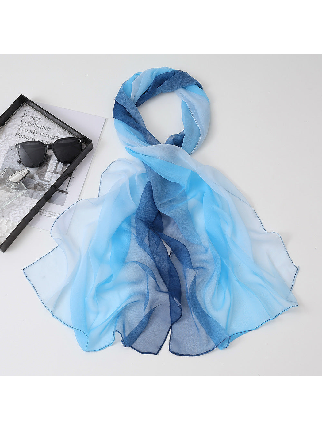 Light blue and navy gradient sheer scarf arranged in a draped loop