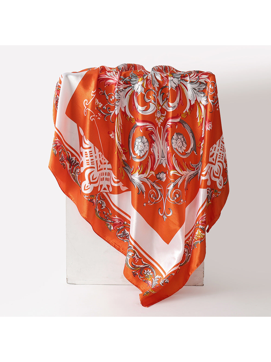 Orange-red square scarf with ornate floral scrollwork and contrasting border