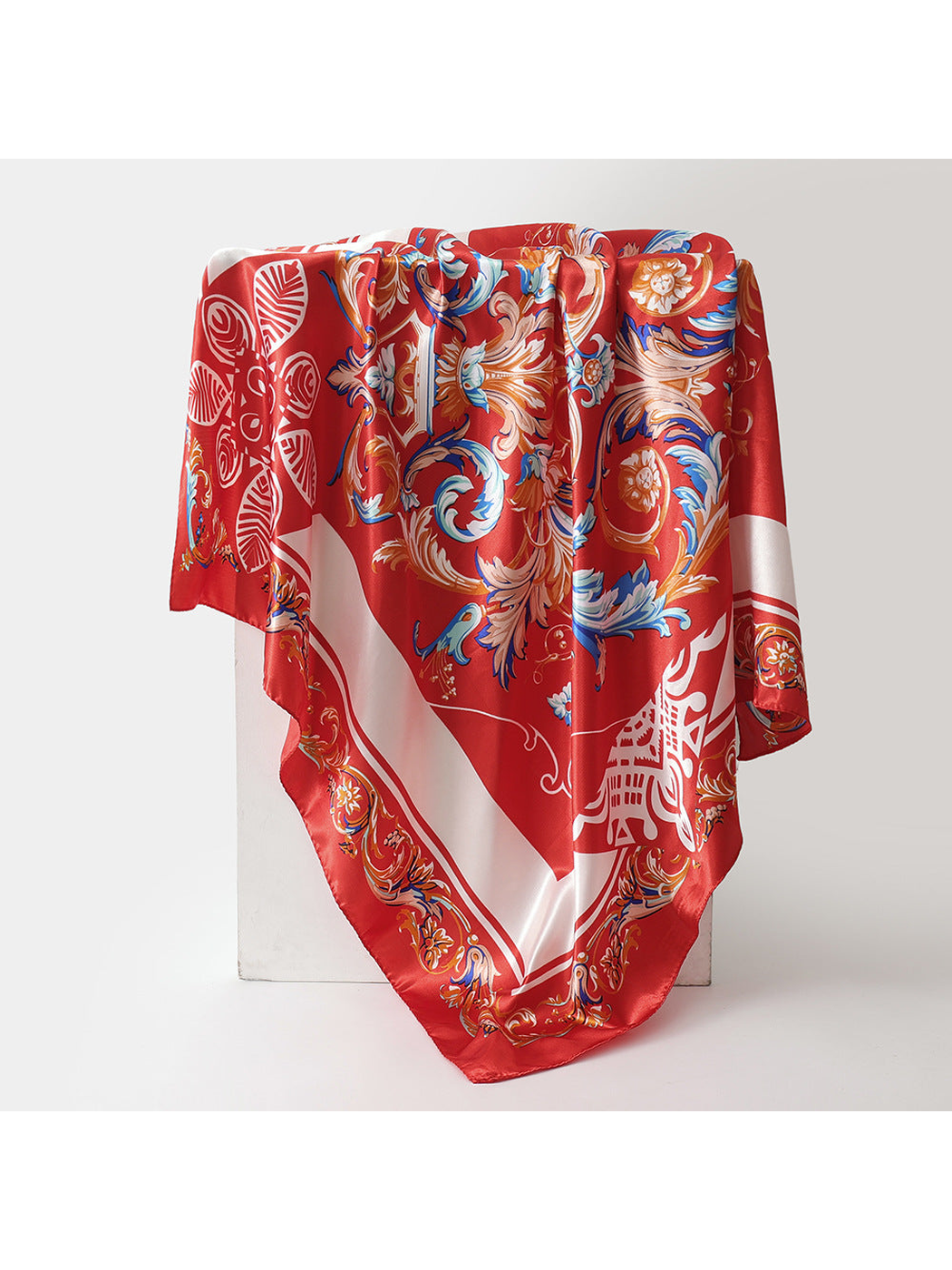 Red square scarf with blue and tan ornamental scrollwork and cream border