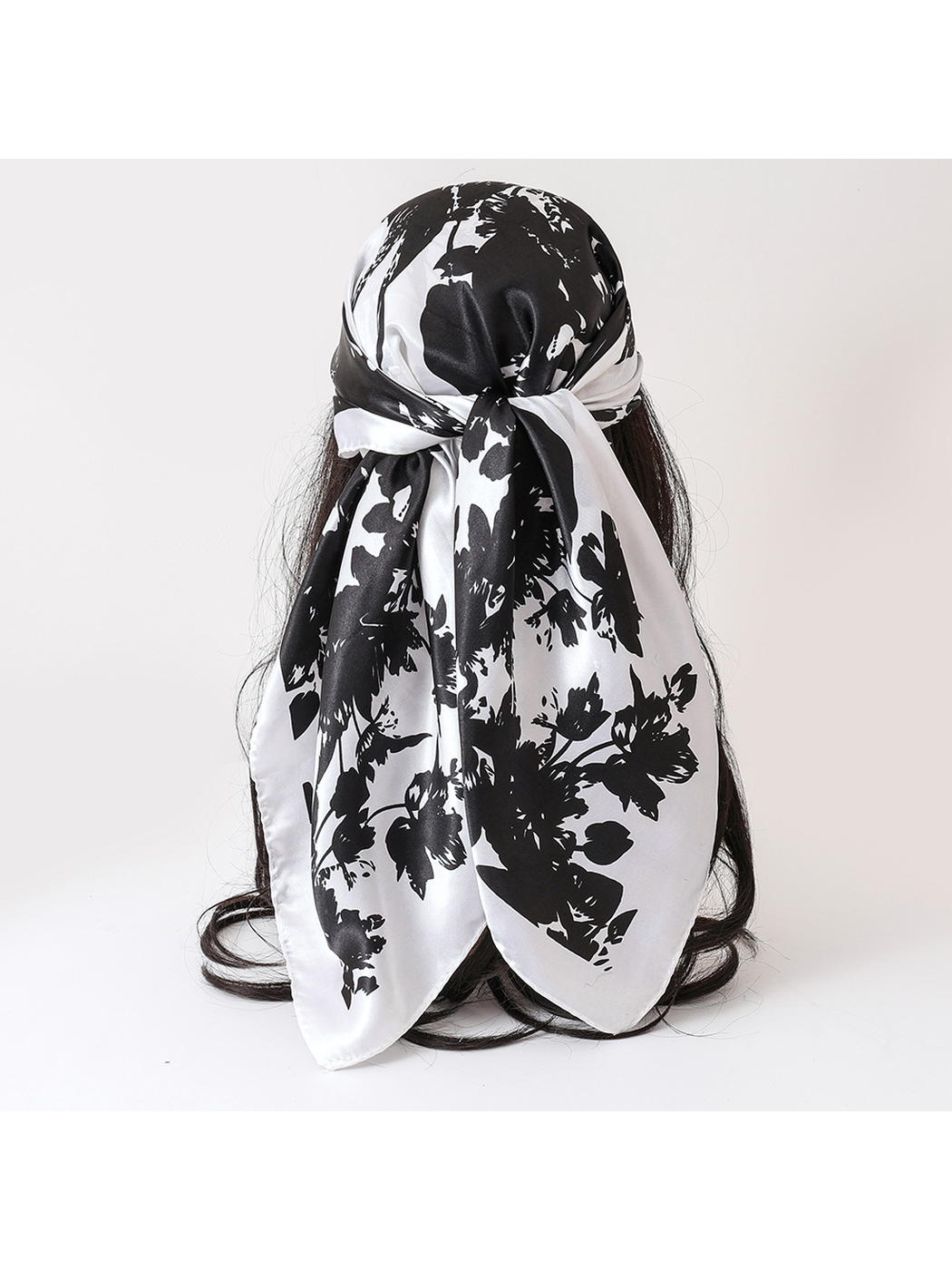 Black-and-white floral square scarf tied at the back of a display head